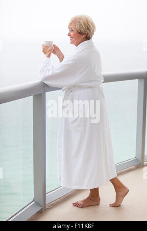 Ältere Frau kaukasischen Kaffeetrinken auf Balkon Stockfoto