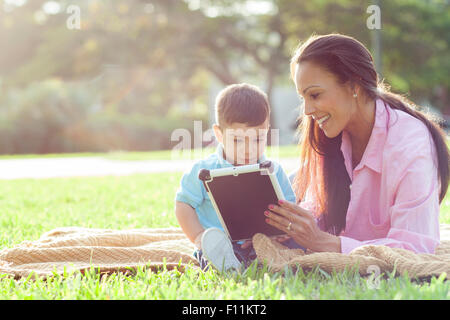 Hispanische Mutter und Sohn im Park lesen Stockfoto