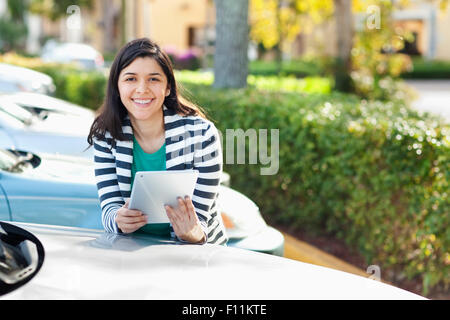 Hispanic Frau mit digital-Tablette auf Parkplatz Stockfoto