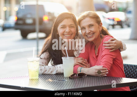 Mutter und Tochter umarmt im Straßencafé Stockfoto