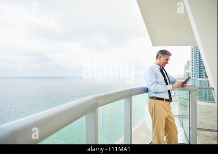 Kaukasische Geschäftsmann mit digital-Tablette auf Balkon Stockfoto