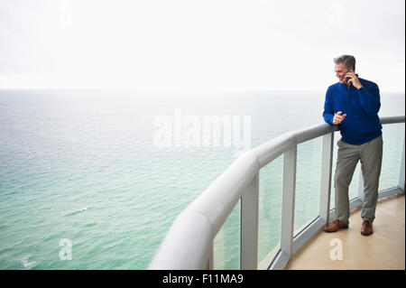 Kaukasische Geschäftsmann reden über Handy auf Balkon Stockfoto