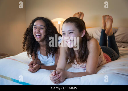 Teenager-Mädchen vor dem Fernseher auf Bett Stockfoto