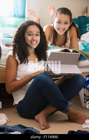 Mädchen im Teenageralter mit digital-Tablette auf Bett Stockfoto