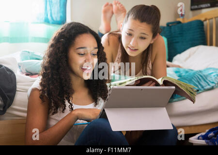 Mädchen im Teenageralter mit digital-Tablette auf Bett Stockfoto