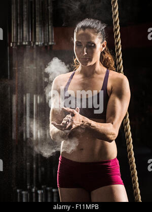 Kaukasische Athlet Kreidung ihre Hände im Fitness-Studio Stockfoto