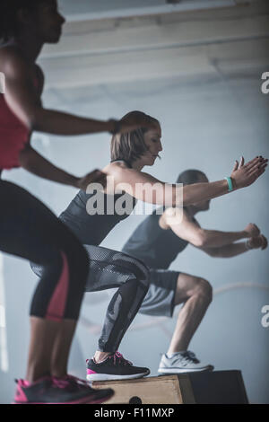 Athleten springen auf Plattformen im Fitness-Studio Stockfoto