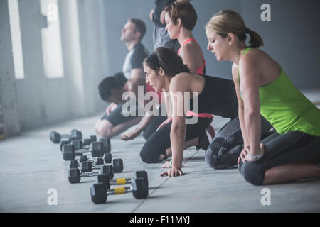 Athleten auf Boden in der Nähe von Hanteln Stockfoto