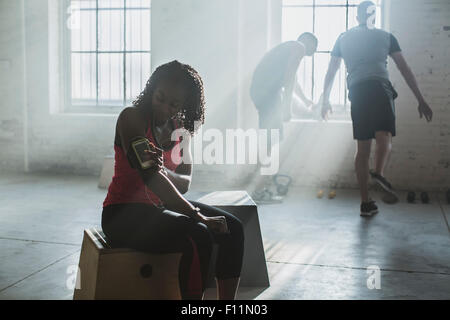 Athlet, anhören von MP3-Player im Fitness-Studio Stockfoto