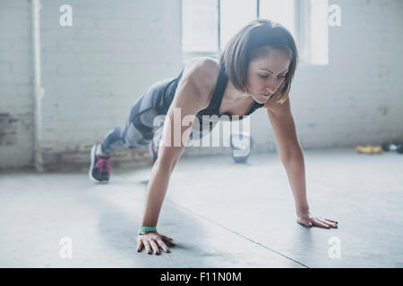 Athlet doing Push-ups im Fitness-Studio Stockfoto