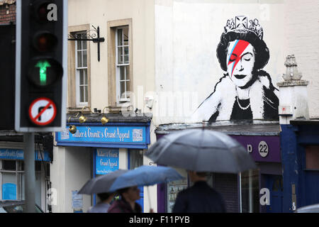 Ein banksy Artwork. Ein Gemälde von Queen Elizabeth, die wie David Bowies Aladin Sane. Die Graffiti ist auf der Seite eines Gebäudes in Bristol GB angezeigt Stockfoto