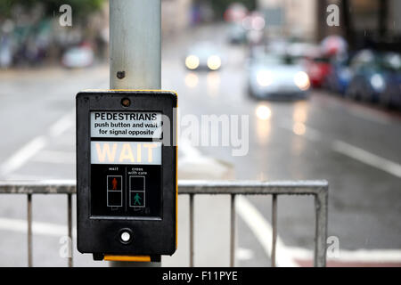 Eine Ampel für die Flurbedienung auf einer belebten Straße der Stadt. Die beleuchteten Straße Fußgänger Schild warten als Fahrzeuge Ansatz der Kreuzung Stockfoto