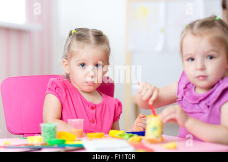 Kinder spielen mit bunten Ton Formen verschiedene Formen Stockfoto