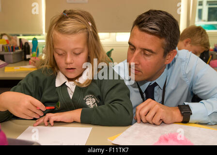 Grundschullehrerin Unterstützung der Schüler im Klassenzimmer, Midlands, UK. Stockfoto