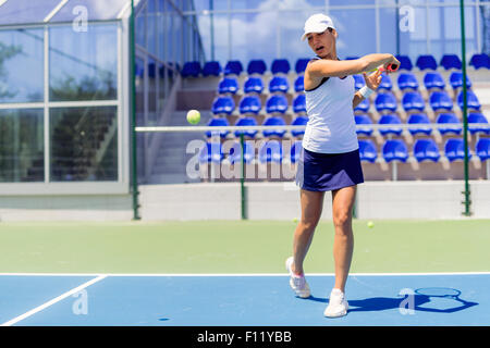 Schöne weibliche Tennisspieler in Aktion, schlagen eine Vorhand Stockfoto