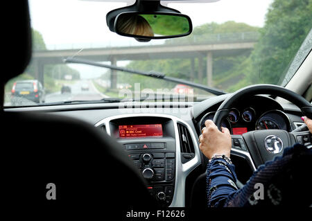 Reife weibliche Autofahrer fahren Auto auf Autobahn im Regen Stockfoto