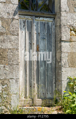Alten geschlagen und beschädigt Holztür Eigenschaft in St Thomas de Conac, Charentes Region, Frankreich Stockfoto