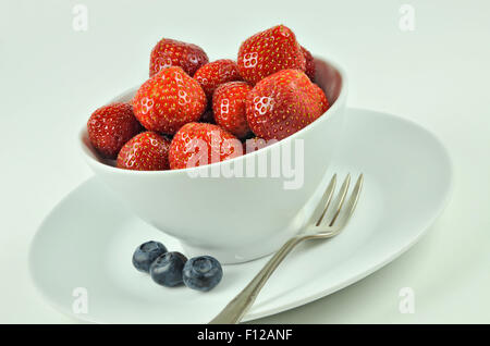 Nahaufnahme einer weißen Schale mit Erdbeeren auf weißem Hintergrund, Makro, Detail, Horizontal, schräg Stockfoto