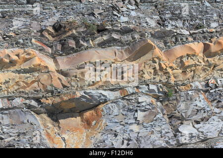 Coastal steilen Berghang mit sichtbaren Gesteinsschichten Stockfoto