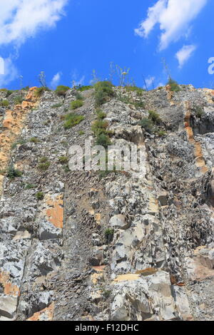 Coastal steilen Berghang mit sichtbaren Gesteinsschichten mit einem Hintergrund des Himmels Stockfoto