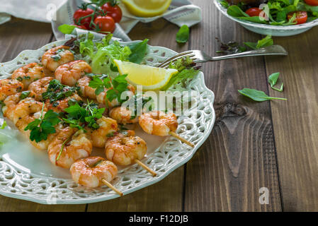 Riesengarnelen am Spieß mit Zitrone garniert Stockfoto