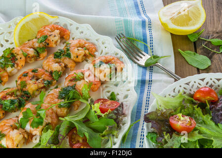 Riesengarnelen am Spieß mit Zitrone garniert Stockfoto