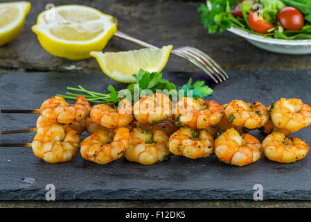 Riesengarnelen am Spieß mit Zitrone garniert Stockfoto