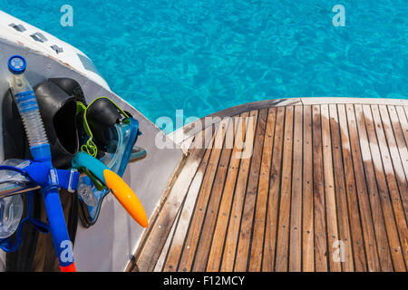 Das abgebildete Boot mit gebogene Holzdeck nass, auf der linken Flossen, Maske, Scuba Rubber zum Schnorcheln und im Hintergrund Ozean Stockfoto