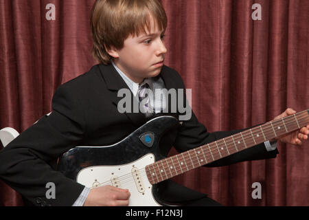 Jungen Alter von 12 Jahren Gitarre spielen schön in einem Jackett und Krawatte gekleidet. St Paul Minnesota MN USA Stockfoto