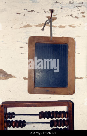 Mini-Tafel hängen alte hölzerne Wand über antike Abakus, zurück zum Schulkonzept Stockfoto