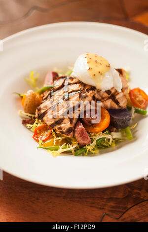 Gegrillter King Lachs-Salat mit Frisee, Pancetta, weichem pochiertem Ei und Senf-Vinaigrette, Bella Vista Restaurant Stockfoto
