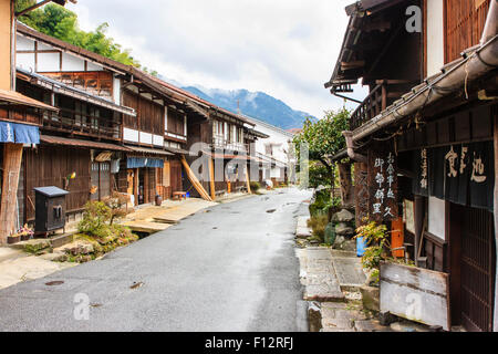 Tsumago, Japan. Blick entlang Terashita Straße auf der Nakasendo Straße, mit Edo Periode traditionelle Gasthäuser und Geschäfte auf beiden Seiten. Bedeckt trüben Himmel. Stockfoto