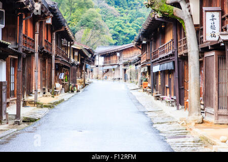 Tsumago, Japan. Blick entlang Terashita Straße auf der Nakasendo Straße, mit Edo Periode traditionelle Gasthäuser und Geschäfte auf beiden Seiten. Bedeckt trüben Himmel. Stockfoto