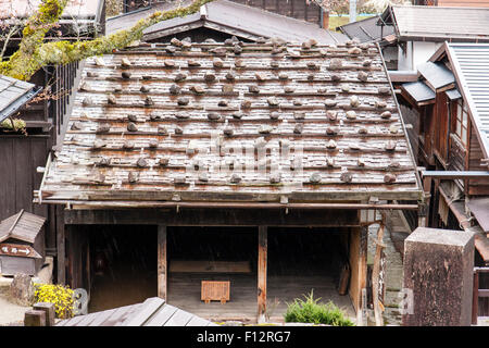 Tsumago, Japan. Terashita Straße auf dem alten Nakasendo Highway. Steine in Reihen auf Ziegeldach, um zu verhindern, dass es sich bei starkem Wind ausgeblasen wird. Stockfoto