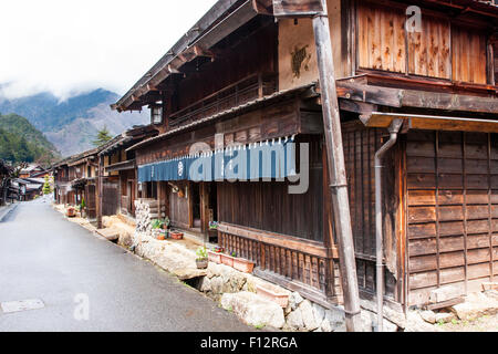 Tsumago, Japan. Blick entlang Terashita Straße auf der Nakasendo Straße, mit Edo Periode traditionelle Gasthäuser und Geschäfte auf beiden Seiten. Bedeckt trüben Himmel. Stockfoto