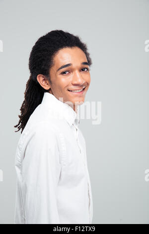 Porträt eines glücklichen jungen Afro amerikanische Geschäftsmann grauen Hintergrund überragt und Blick in die Kamera Stockfoto