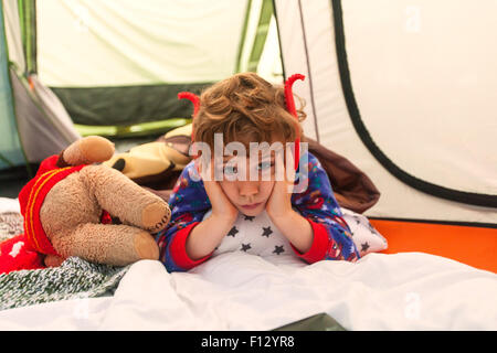 Sechs Jahre alten Jungen Gelangweilt beim Camping. Karrageen Campingplatz, Hope Cove, Devon, England, Vereinigtes Königreich. Stockfoto