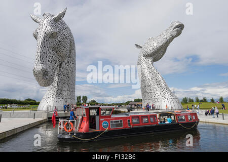 Die Kelpies Skulptur von zwei Pferden überqueren Forth und Clyde Canal und touristischen Kanalboot im The Helix Park, Falkirk, Schottland Stockfoto