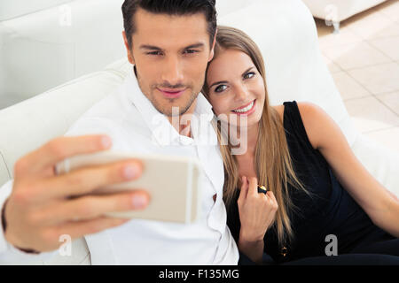 Junges Paar Smartphone drinnen Selfie Foto zu Lächeln Stockfoto