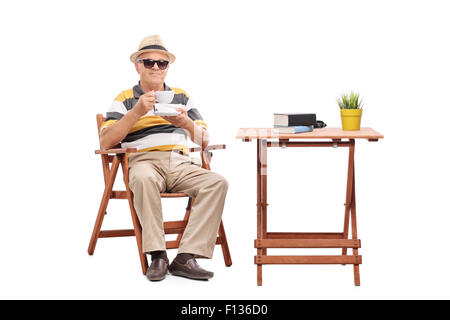 Senioren Herren am Tisch sitzen und trinken eine Tasse Kaffee, die isoliert auf weißem Hintergrund Stockfoto