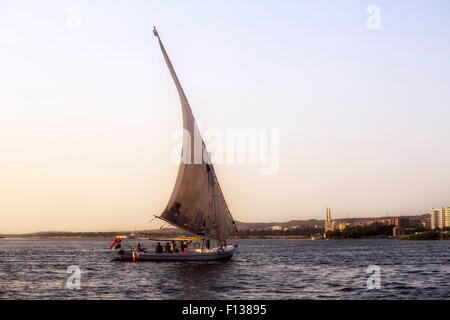 Segeln eine Feluke auf dem Nil im Sonnenuntergang in der Nähe von Assuan, Ägypten, Afrika Stockfoto