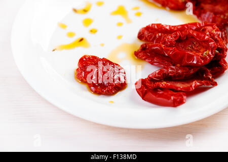 Getrocknete Tomaten mit Olivenöl auf weißen Teller Stockfoto