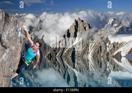 Weibliche Extrembergsteiger hängen auf Felsen über dem See Stockfoto