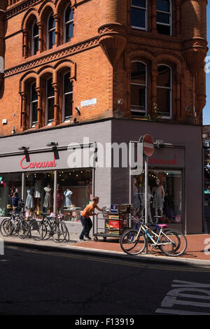 Lieferung Mann schieben Karren, beladen mit Bierfässern und Kisten von alkoholischen Getränken auf Drury Straße in Dublins Kreativquartier Stockfoto