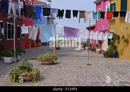 Wäscheständer auf Linien zwischen bunten Häusern in Burano, Venedig, Italien Stockfoto