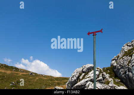 Rote Wegweiser in den Bergen rote Wegweiser in den Bergen gegen blauen Wolkenhimmel Stockfoto