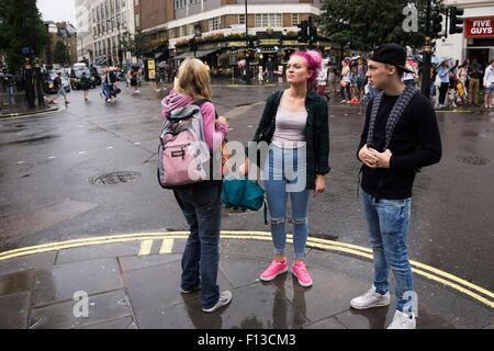 London, UK. Sonntag, 23. August 2015. Schwere Regen Sommerduschen im West End. Menschen mutig die Nässe, bewaffnet mit Sonnenschirme und wetterfeste Kleidung. Stockfoto