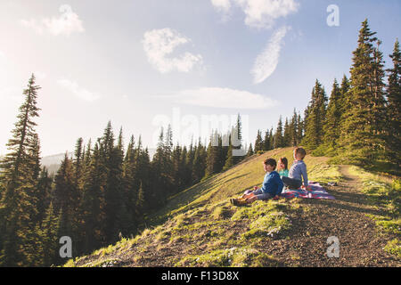 Drei Kinder sitzen auf einem Berg Stockfoto