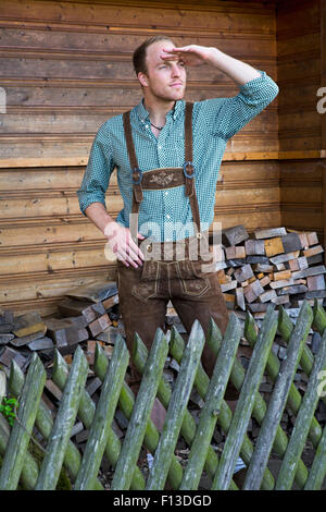 junger Mann in bayerischen Lederhosen stehen und blickte in die Ferne Stockfoto