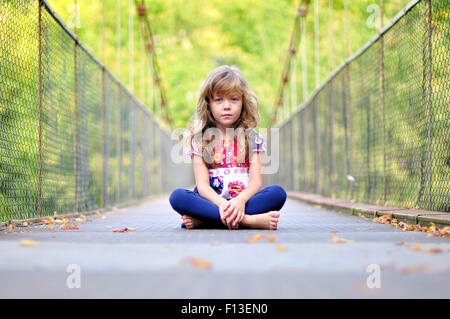 Porträt eines Mädchens sitzen auf einer Brücke Stockfoto